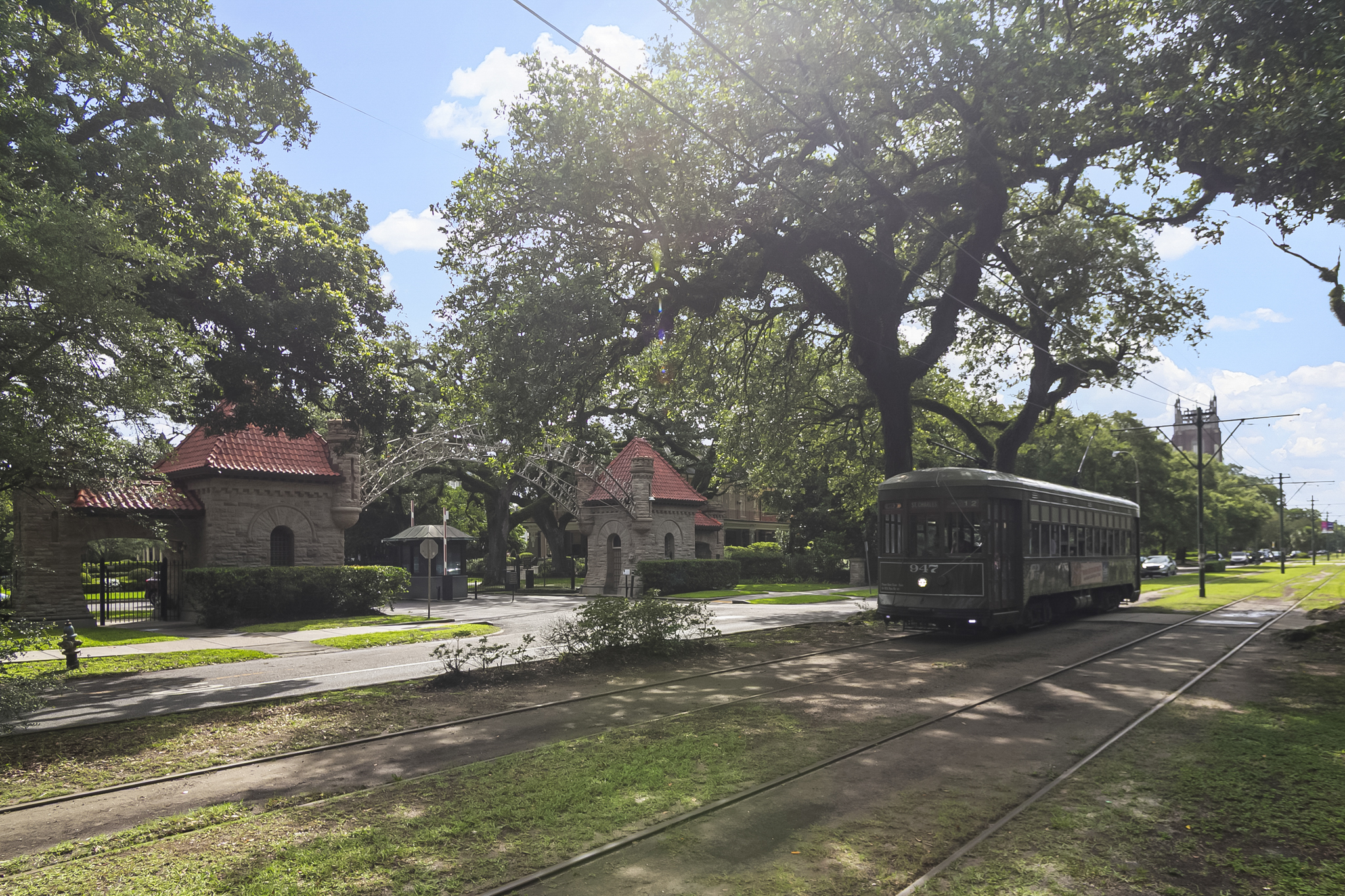 The St. Charles Avenue streetcar passing the oak-lined entrance to Audubon Park in New Orleans